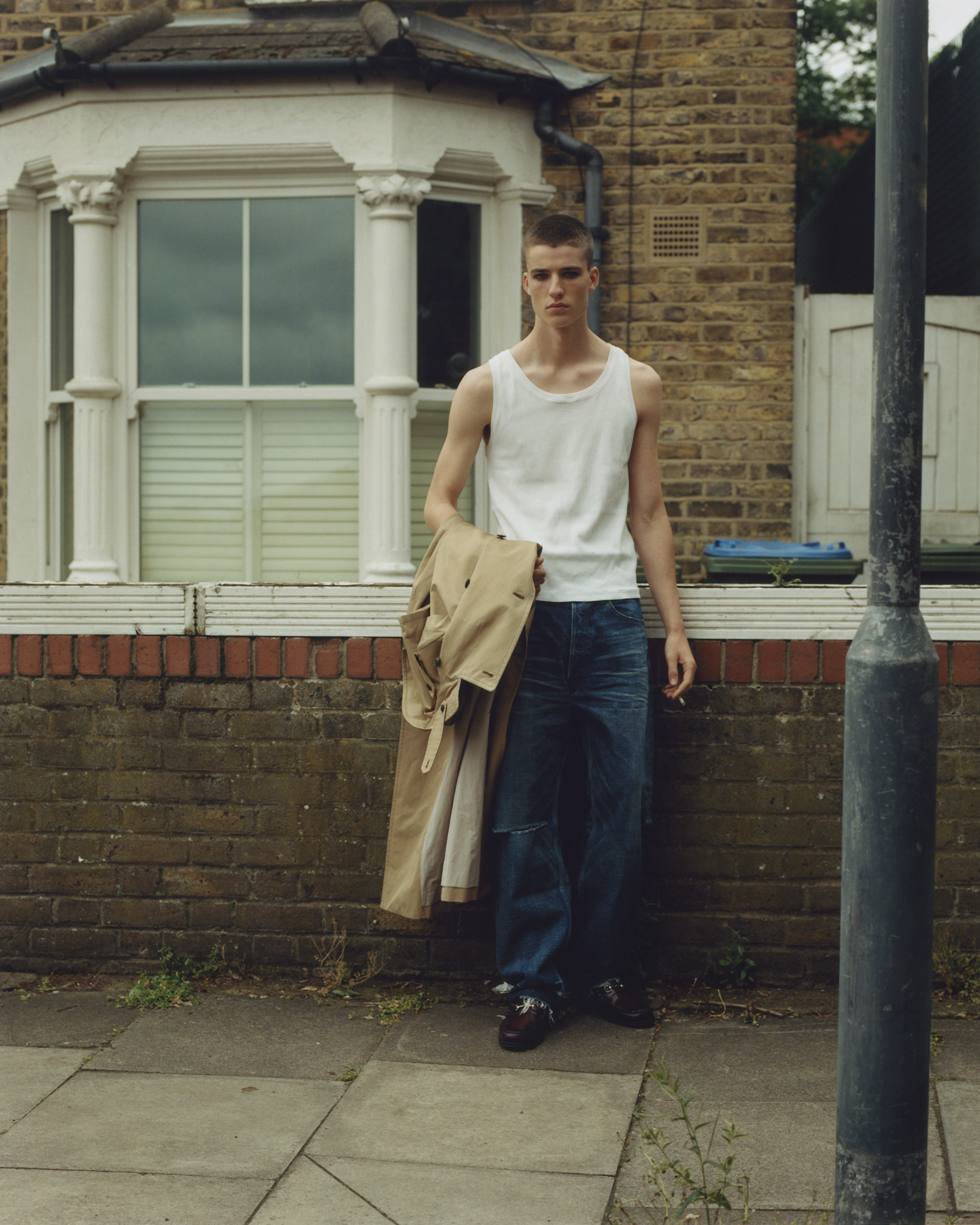 Ned wears denim by CELINE, trench coat by TOGA, loafers by G.H. BASS